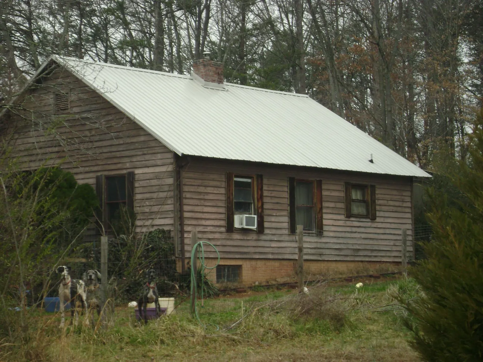 White metal roof on an old wood sided farmhouse, from a Metal Roof Installation job in Crookston